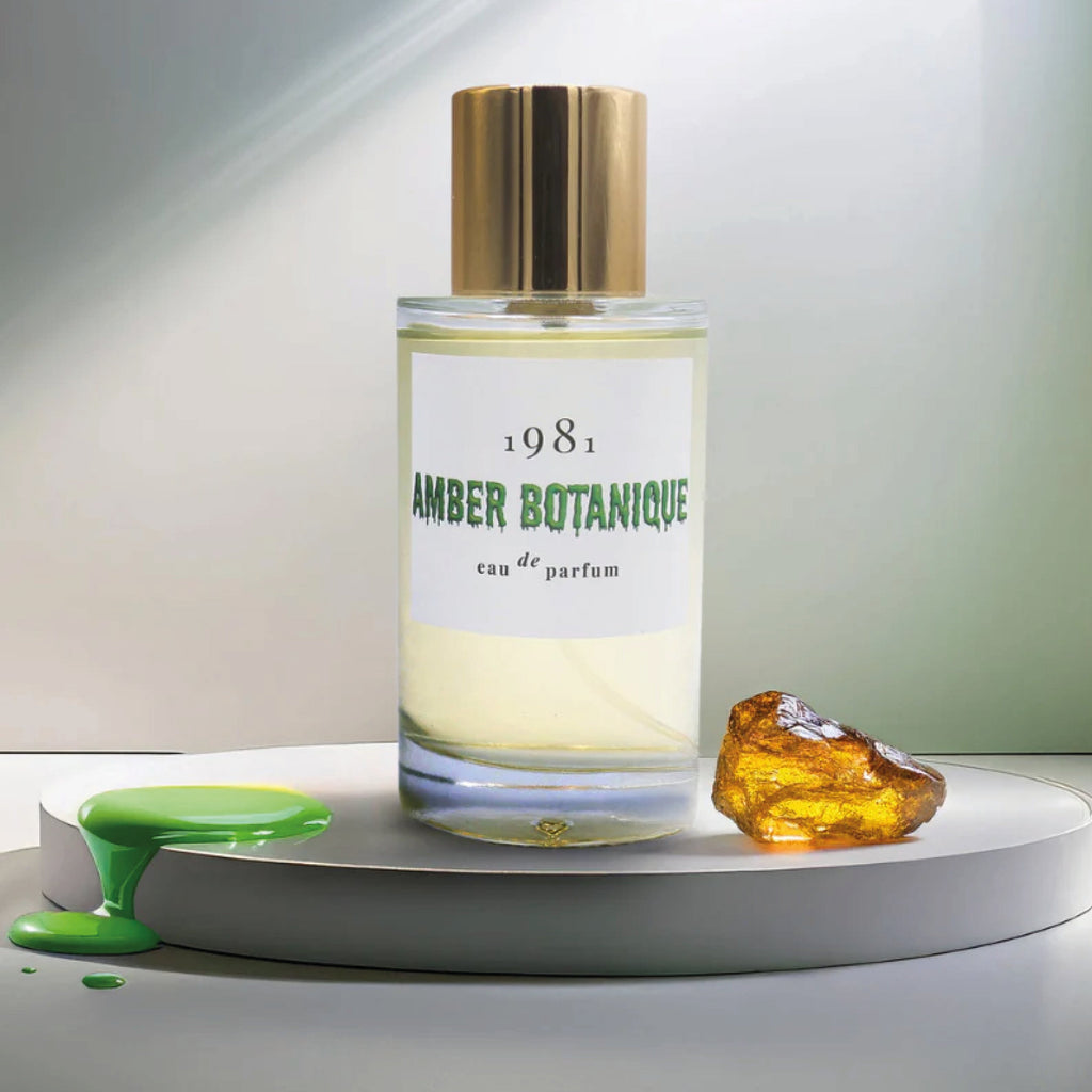 Perfume bottle labeled '1981 Amber Botanique' with a green label on a white platform.
1981 Eau de Parfum Amber Botanique Fragrance - Jo And Co 1981 Eau de Parfum Amber Botanique Fragrance - 1981