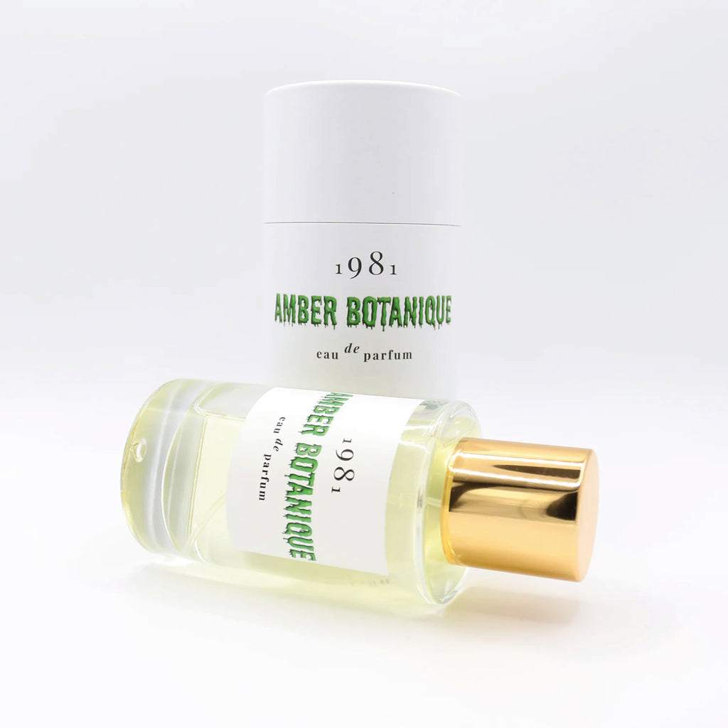 Perfume bottle labeled '1981 Amber Botanique' with a green label on a white platform.
1981 Eau de Parfum Amber Botanique Fragrance - Jo And Co 1981 Eau de Parfum Amber Botanique Fragrance - 1981