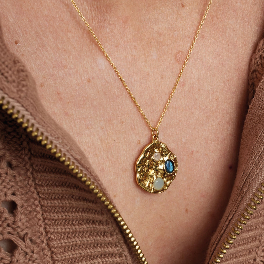 Textured gold coin necklace with three inset gemstones: aqua chalcedony, rainbow moonstone, and labradorite.
Ashiana London Rhode Gemstone Coin Pendant Necklace - Jo And Co Ashiana London Rhode Gemstone Coin Pendant Necklace - Ashiana London