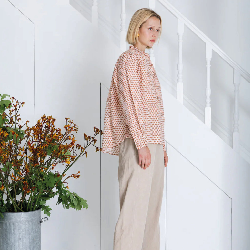 Red and white patterned blouse in cotton cambric woodblock print, with frill around the neck and front half placket.
Bonté Cinnamon Blush Anais Shirt - Jo And Co Bonté Cinnamon Blush Anais Shirt - Bonté