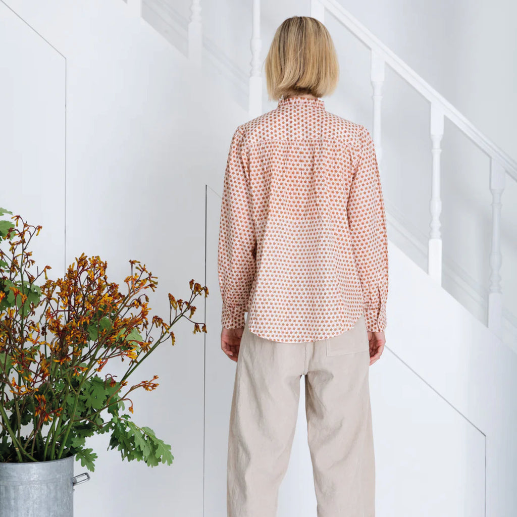 Red and white patterned blouse in cotton cambric woodblock print, with frill around the neck and front half placket.
Bonté Cinnamon Blush Anais Shirt - Jo And Co Bonté Cinnamon Blush Anais Shirt - Bonté