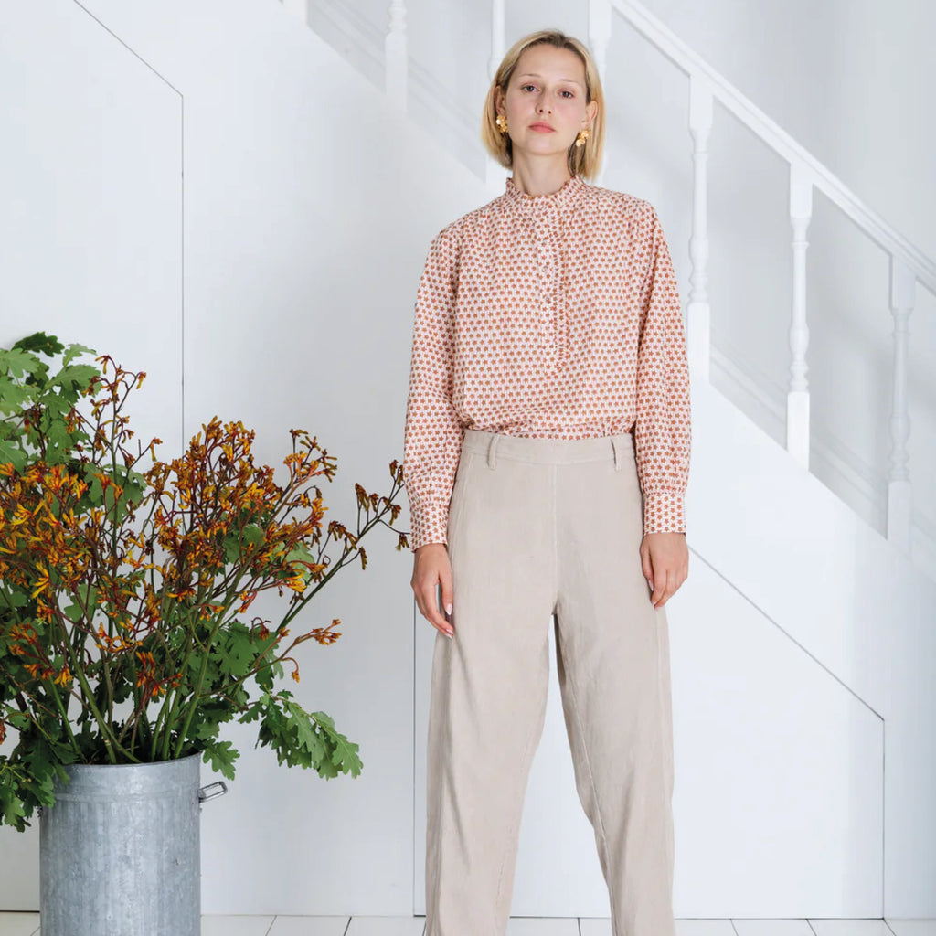 Red and white patterned blouse in cotton cambric woodblock print, with frill around the neck and front half placket.
Bonté Cinnamon Blush Anais Shirt - Jo And Co Bonté Cinnamon Blush Anais Shirt - Bonté