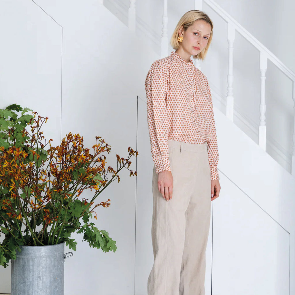 Red and white patterned blouse in cotton cambric woodblock print, with frill around the neck and front half placket.
Bonté Cinnamon Blush Anais Shirt - Jo And Co Bonté Cinnamon Blush Anais Shirt - Bonté
