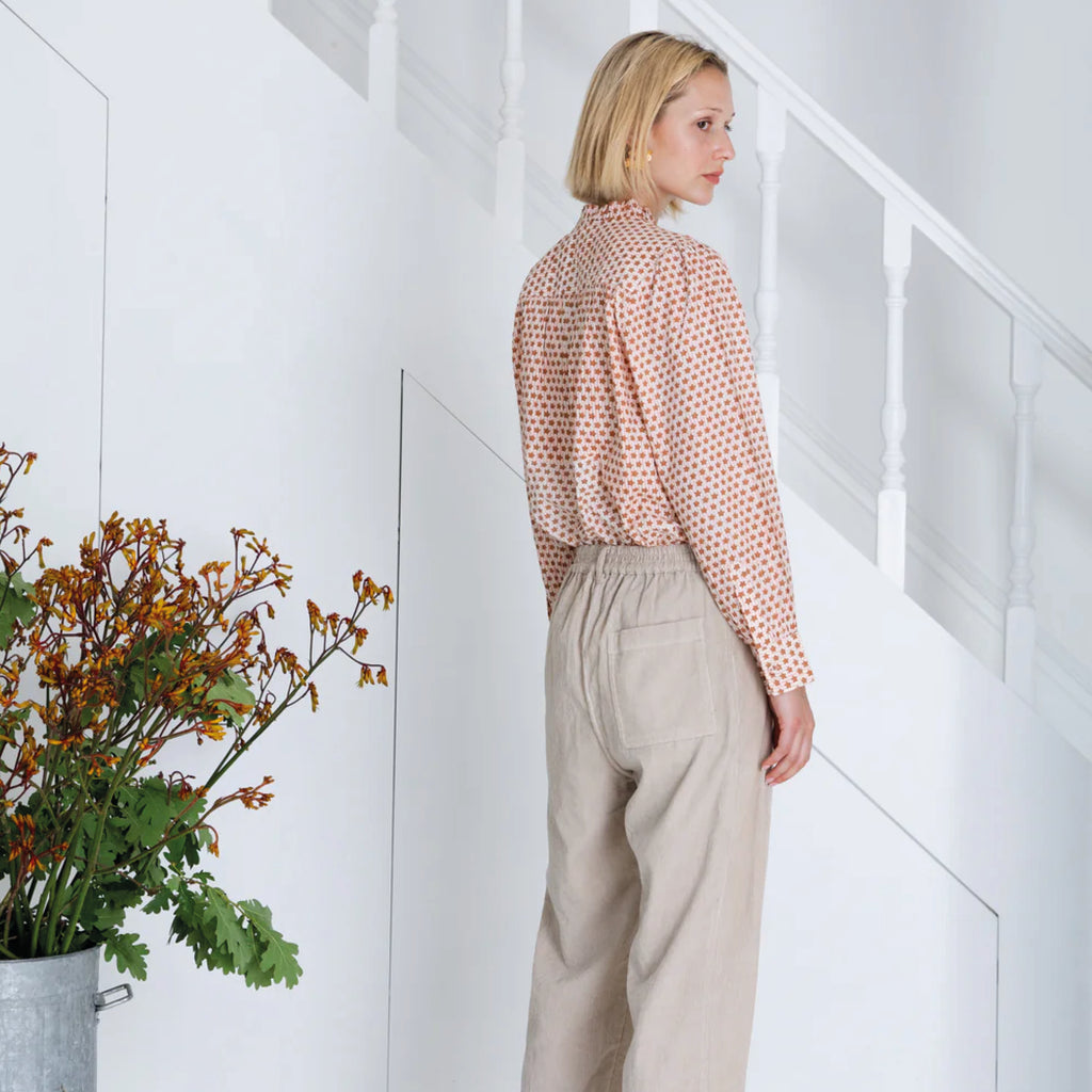 Red and white patterned blouse in cotton cambric woodblock print, with frill around the neck and front half placket.
Bonté Cinnamon Blush Anais Shirt - Jo And Co Bonté Cinnamon Blush Anais Shirt - Bonté