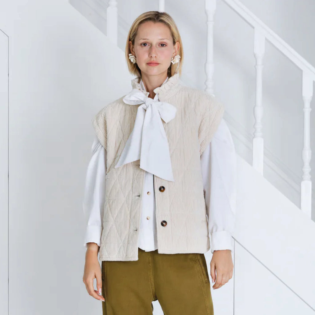 Ecru gilet with grown on shoulder, frill detail on a collar-stand curved hem at the side seams.
Bonté Ecru Stina Gilet - Jo And Co Bonté Ecru Stina Gilet - Bonté