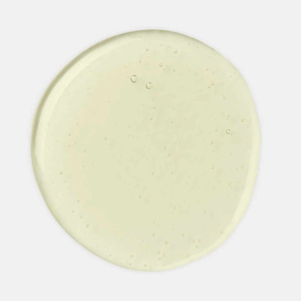 Clear light yellow Geranium No.1 Bath Oil drop with bubbles visible on white background
