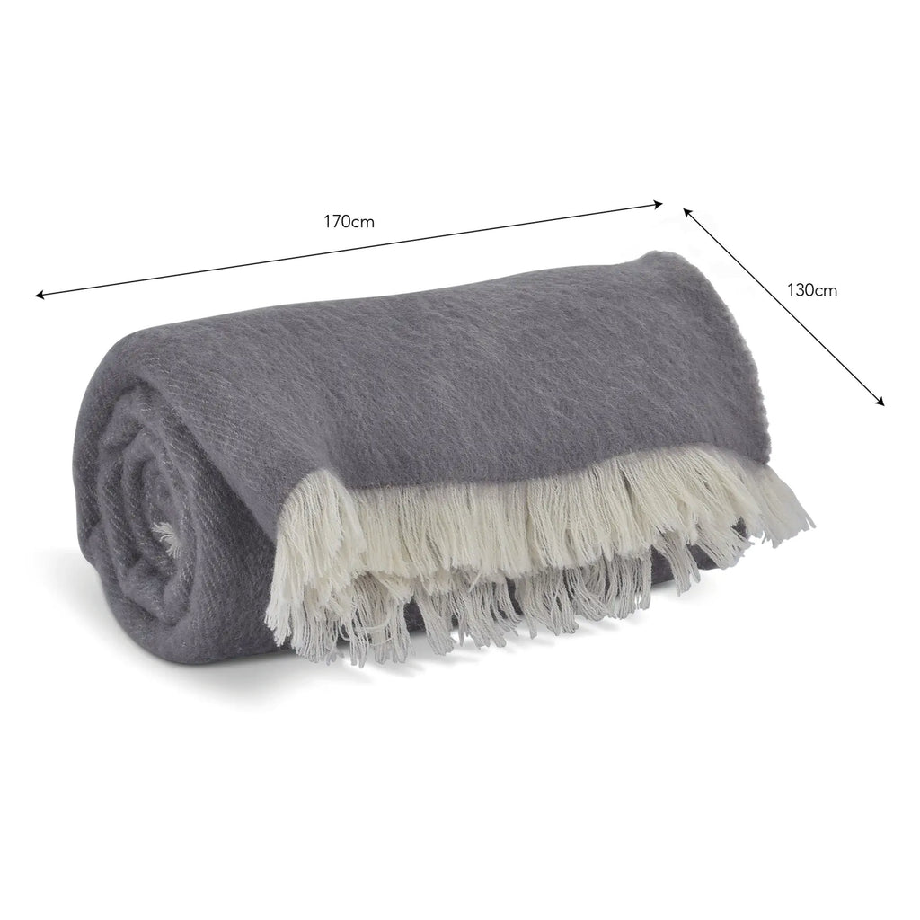 Rolled-up grey throw blanket with white fringe in 100% New Zealand wool.
Grey Wool Leigh Reversible Throw - Jo And Co Grey Wool Leigh Reversible Throw