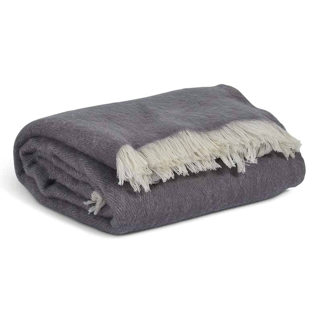 Rolled-up grey throw blanket with white fringe in 100% New Zealand wool.
Grey Wool Leigh Reversible Throw - Jo And Co Grey Wool Leigh Reversible Throw