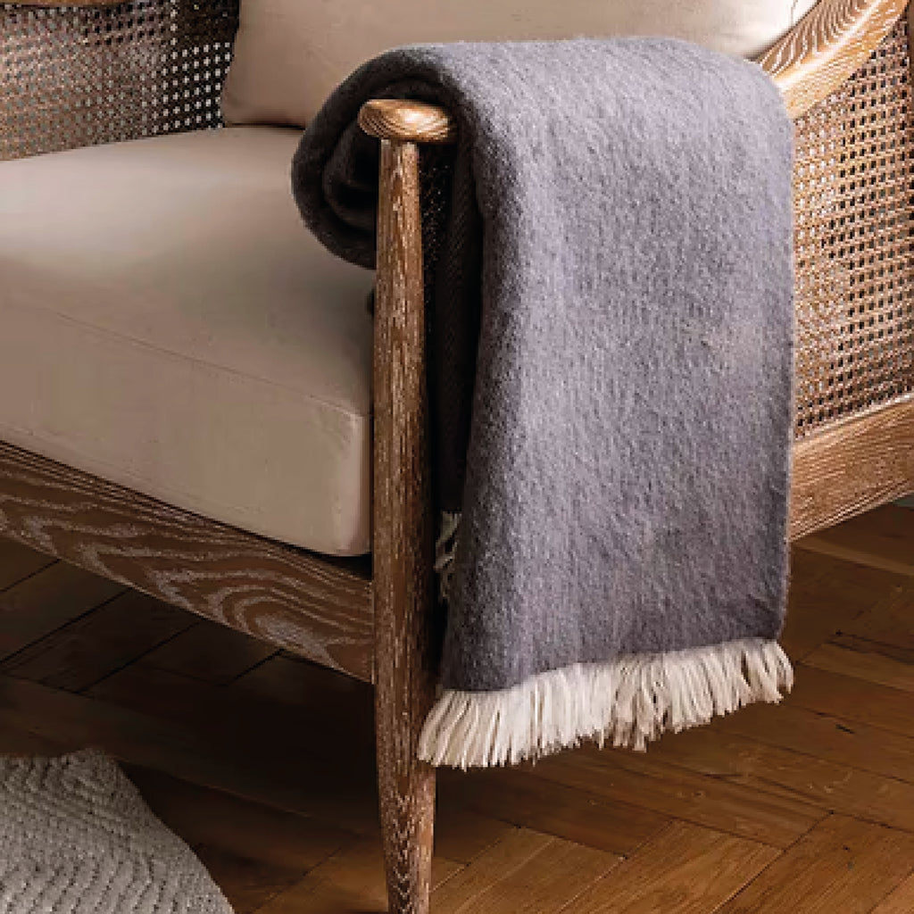 Rolled-up grey throw blanket with white fringe in 100% New Zealand wool.
Grey Wool Leigh Reversible Throw - Jo And Co Grey Wool Leigh Reversible Throw