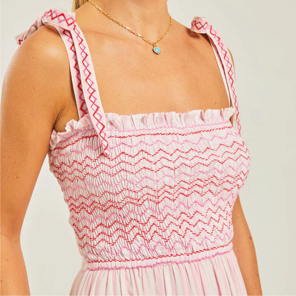 Jo And Co Pink City Prints Hollyhock Stripe Jessica Dress_Crafted from soft, hand-loomed cotton in the prettiest shades of pink and white, our Jessica dress is a versatile and effortless addition to your spring wardrobe. With a flattering hand-smocked body and embroidered zigzag details throughout, the Jessica dress is finished with adjustable tie straps and a shirred back to create the perfect fit. The fabric has the most beautiful drape and feel, you won’t want to take this off!