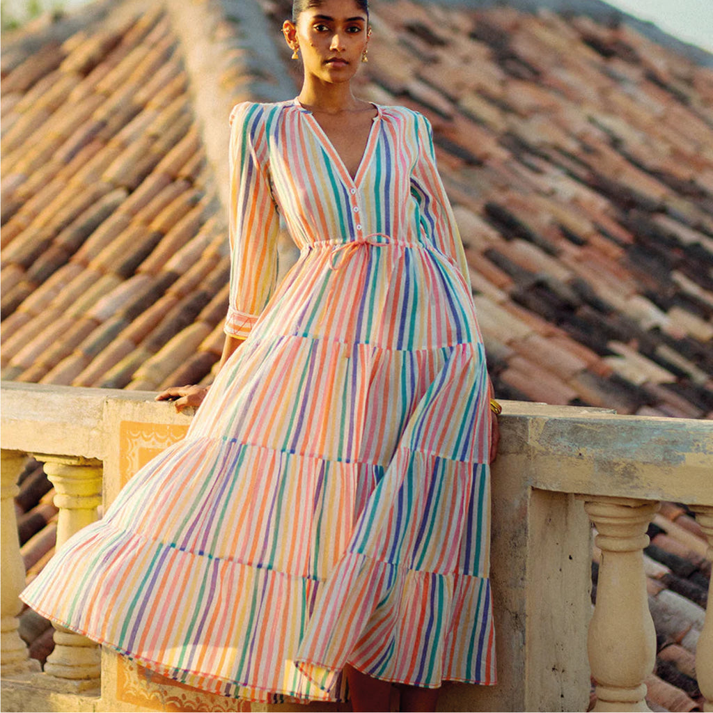 Jo And Co Pink City Prints Rainbow Stripe Sofia Dress_Crafted from soft, hand-loomed cotton in the prettiest Rainbow Stripe, our new Sofia dress is an effortless wardrobe favourite. With a flattering, v-neckline, comfortable drawstring waistband and pretty tiered skirt, the Sofia dress is finished with a playful zig-zag stitch at the cuffs. The hand-loomed cotton fabric drapes beautifully and is a real treat to wear.