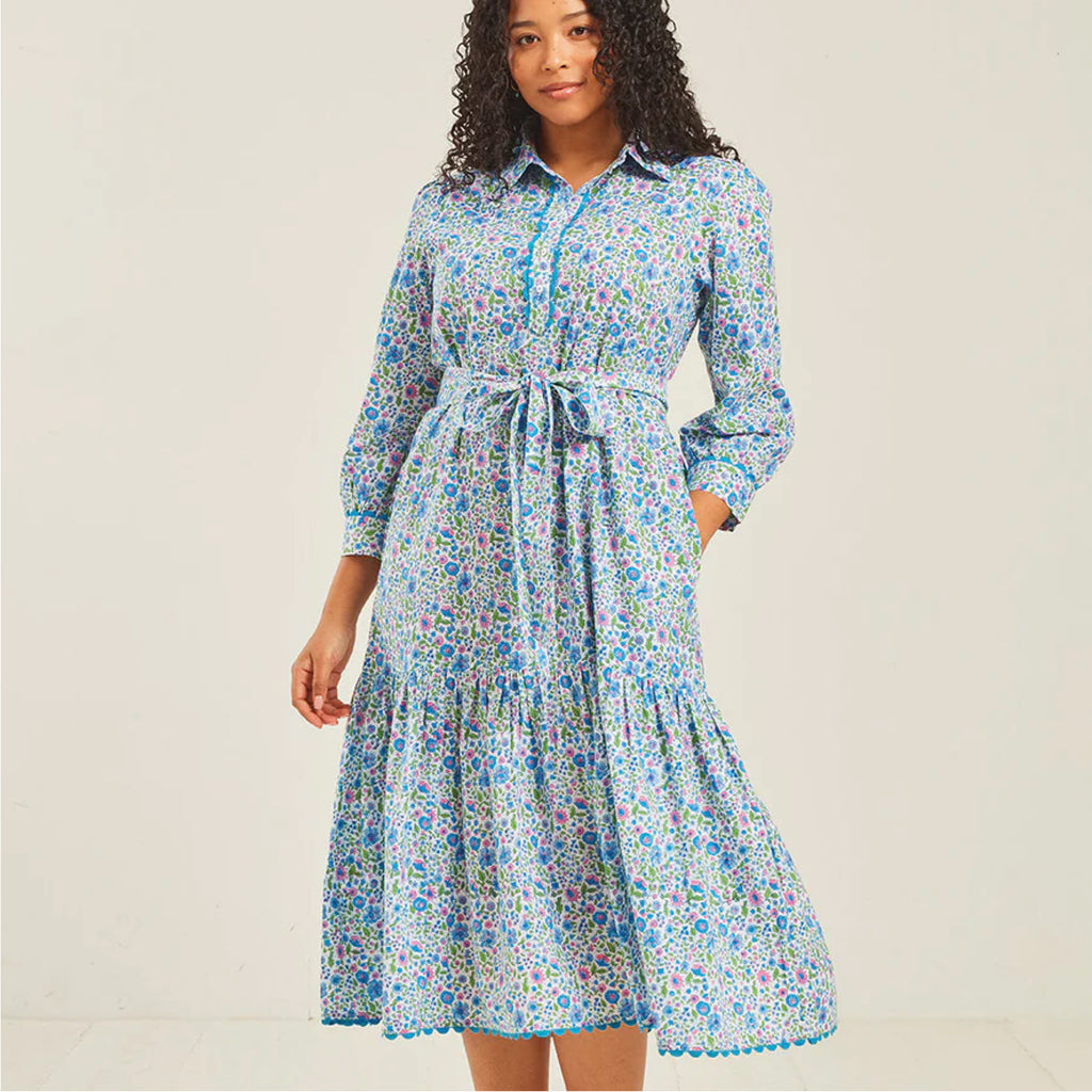 Jo And Co Pink City Prints Sky Meadow Margot Dress_Block-printed by hand in our pretty, new Sky Meadow ditsy, the Margot dress is a flattering and versatile wardrobe favourite. Finished with a pretty, blue ric-rac trim, the Margot dress features a neat collar and placket, relaxed, waistless fit and full length sleeves with a ricrac trimmed cuffed. Wear loose for an effortless look, or cinch in your waist with the matching belt to dress up the Margot for special occasions.