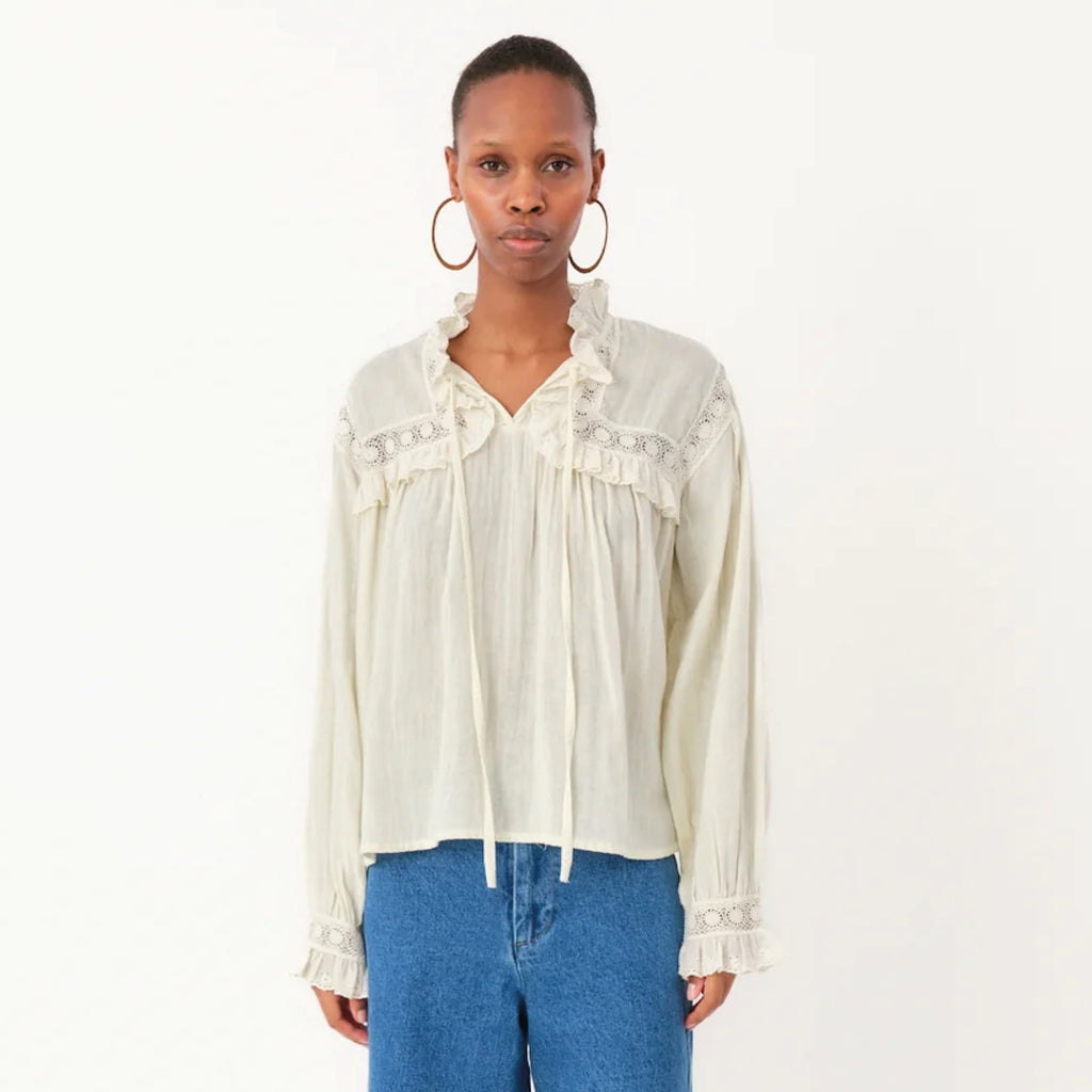 White shirt with decorative yoke with ruffles and lace ribbon, long sleeves with wide cuffs and broderie anglaise and lace trim.
Lollys Laundry Creme Gemma Shirt - Jo And Co Lollys Laundry Creme Gemma Shirt - Lollys Laundry