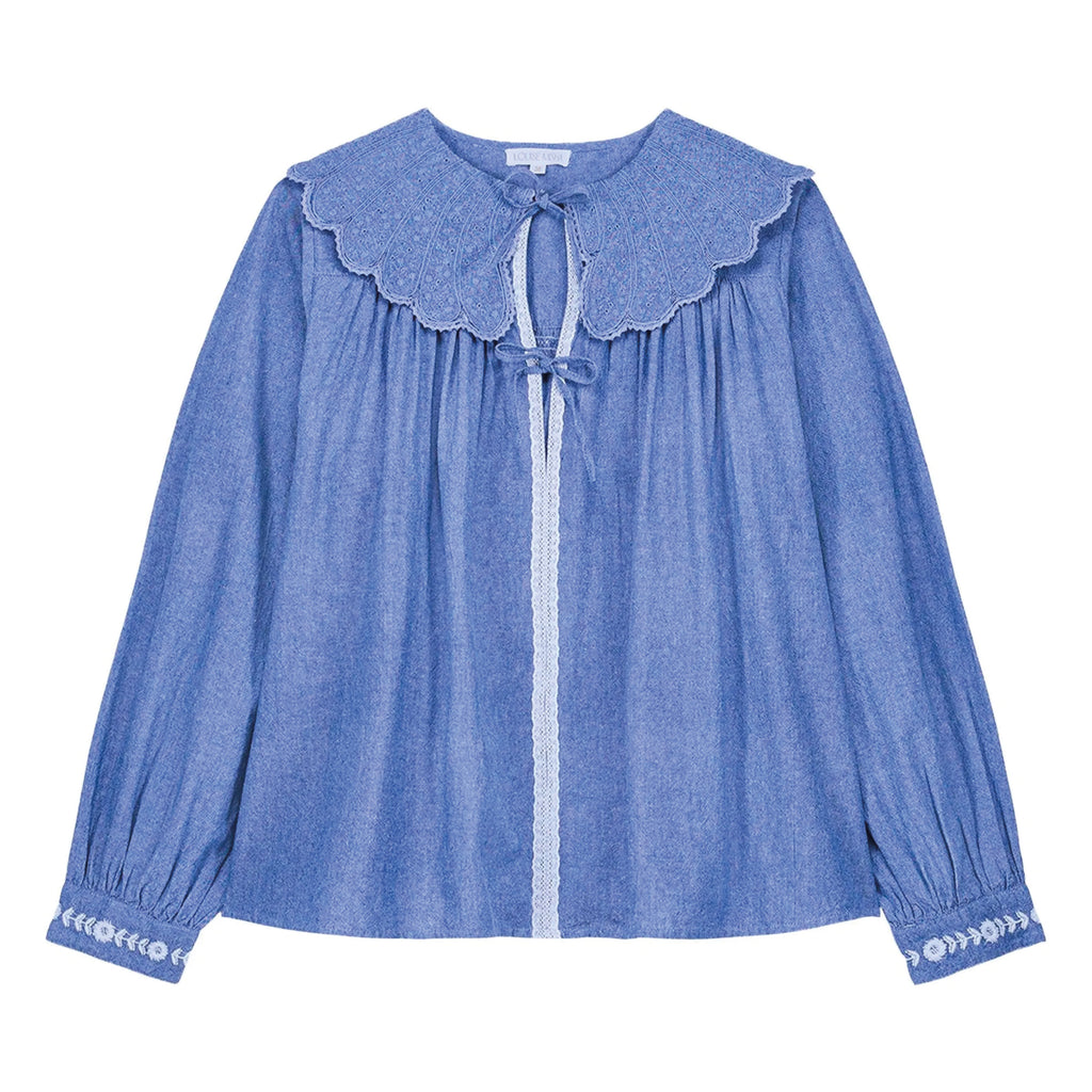 Blue blouse with petal-effect collar in tone-on-tone broderie anglaise with lace trim.
Louise Misha Blue Chambray Hyacia Blouse - Jo And Co Louise Misha Blue Chambray Hyacia Blouse - Louise Misha
