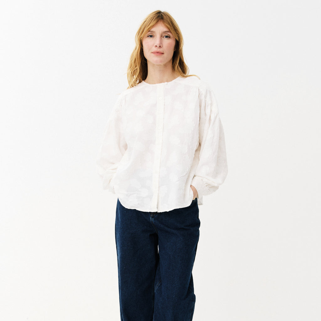 White blouse with cloud-like embroidery, button front, rounded neckline, slightly puffed sleeves with buttoned-cuffs and a gathered yoke at the back. 
Maison Anana White Aniella Blouse - Jo And Co Maison Anana White Aniella Blouse - Maison Anana