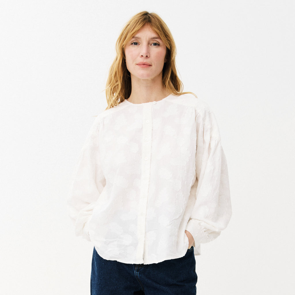 White blouse with cloud-like embroidery, button front, rounded neckline, slightly puffed sleeves with buttoned-cuffs and a gathered yoke at the back. 
Maison Anana White Aniella Blouse - Jo And Co Maison Anana White Aniella Blouse - Maison Anana
