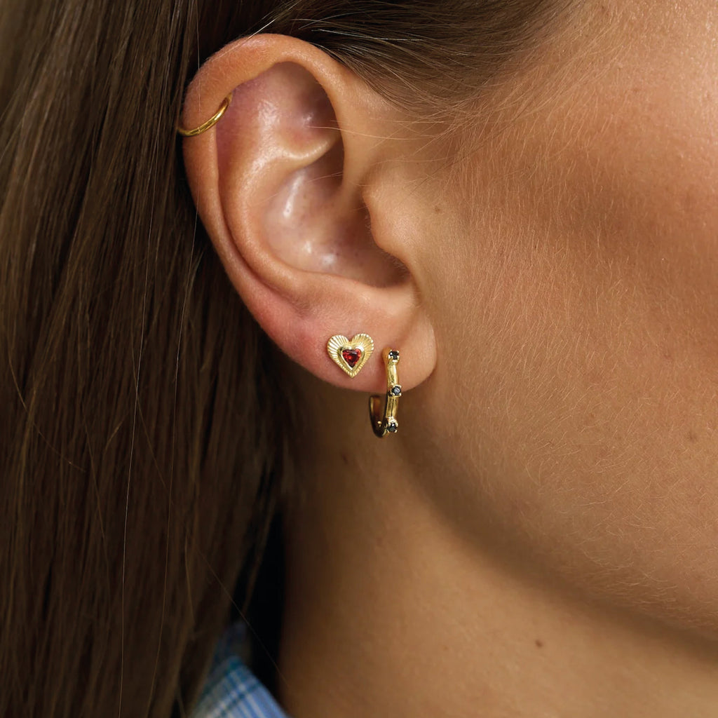 Gold heart-shaped earrings with a red gemstone.
Rhapsody Love Stud Gold Plated Earrings - Jo And Co Rhapsody Love Stud Gold Plated Earrings - Anna + Nina