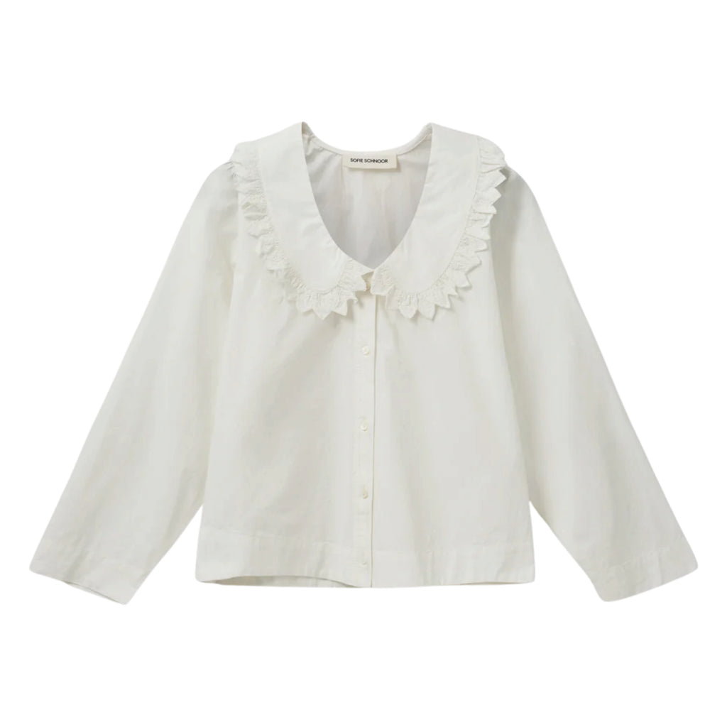 White shirt with short boxy fit, puff sleeves and Peter Pan collar with embroidered frill edge.
Sofie Schnoor Cream Manon Shirt - Jo And Co Sofie Schnoor Cream Manon Shirt - Sofie Schnoor