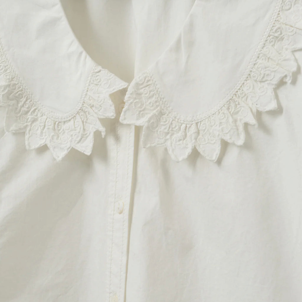 White shirt with short boxy fit, puff sleeves and Peter Pan collar with embroidered frill edge.
Sofie Schnoor Cream Manon Shirt - Jo And Co Sofie Schnoor Cream Manon Shirt - Sofie Schnoor
