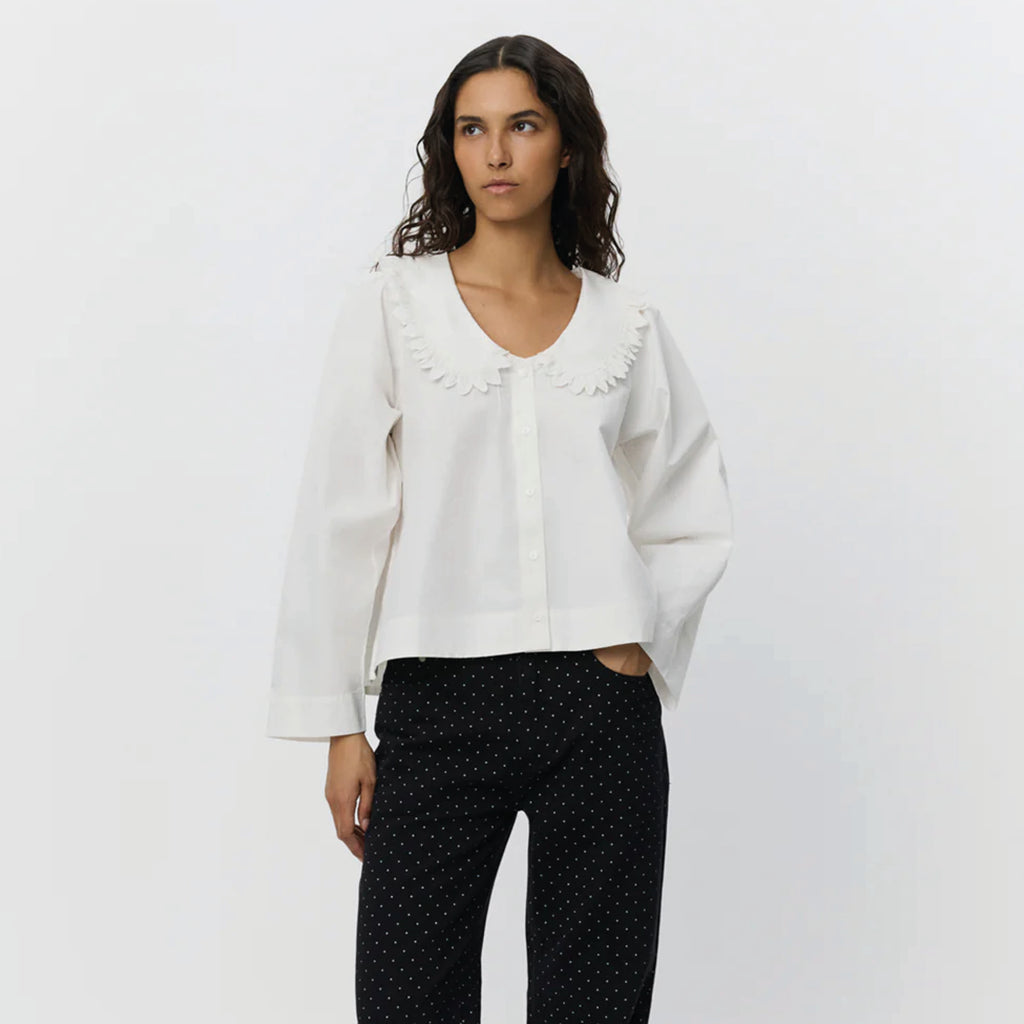 White shirt with short boxy fit, puff sleeves and Peter Pan collar with embroidered frill edge.
Sofie Schnoor Cream Manon Shirt - Jo And Co Sofie Schnoor Cream Manon Shirt - Sofie Schnoor