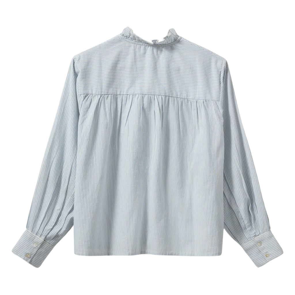 Light blue striped shirt with frilled collar with decorative edge along button placket and wrinkle details on shoulders.
Sofie Schnoor Light Blue Striped Edna Shirt - Jo And Co Sofie Schnoor Light Blue Striped Edna Shirt - Sofie Schnoor