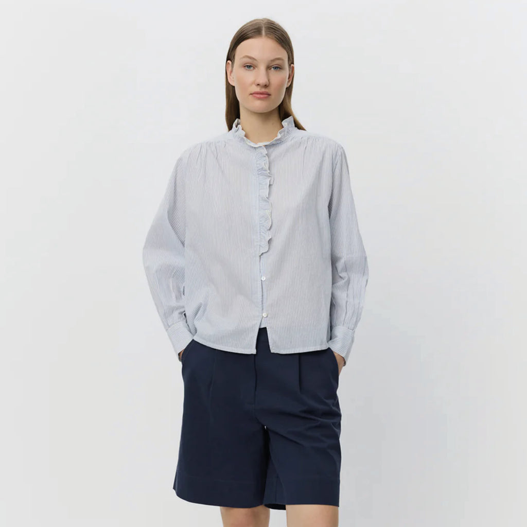 Light blue striped shirt with frilled collar with decorative edge along button placket and wrinkle details on shoulders.
Sofie Schnoor Light Blue Striped Edna Shirt - Jo And Co Sofie Schnoor Light Blue Striped Edna Shirt - Sofie Schnoor
