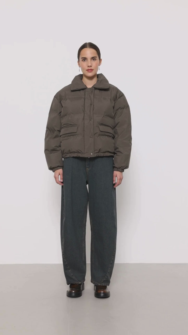 Brown puffer jacket with high, wide collar, front button closure, front pockets and adjustable drawstrings at the hem.
Leveté Room Coffee Mona Coat  - Jo And Co Leveté Room Coffee Mona Coat - Leveté Room